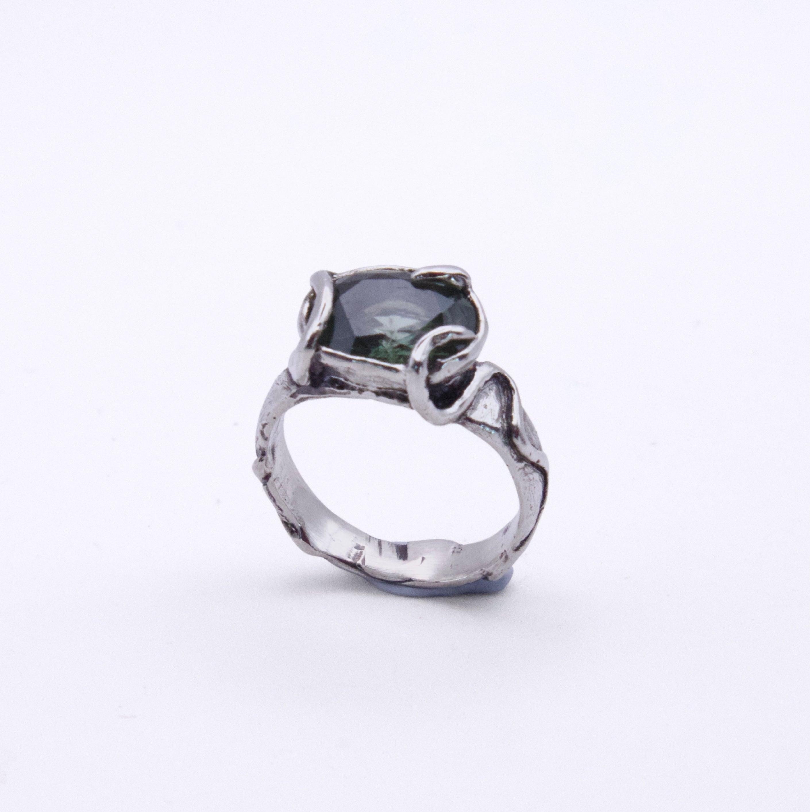 A silver ring with a textured, organic-shaped band and a dark green rectangular gemstone, shown on a plain white background.