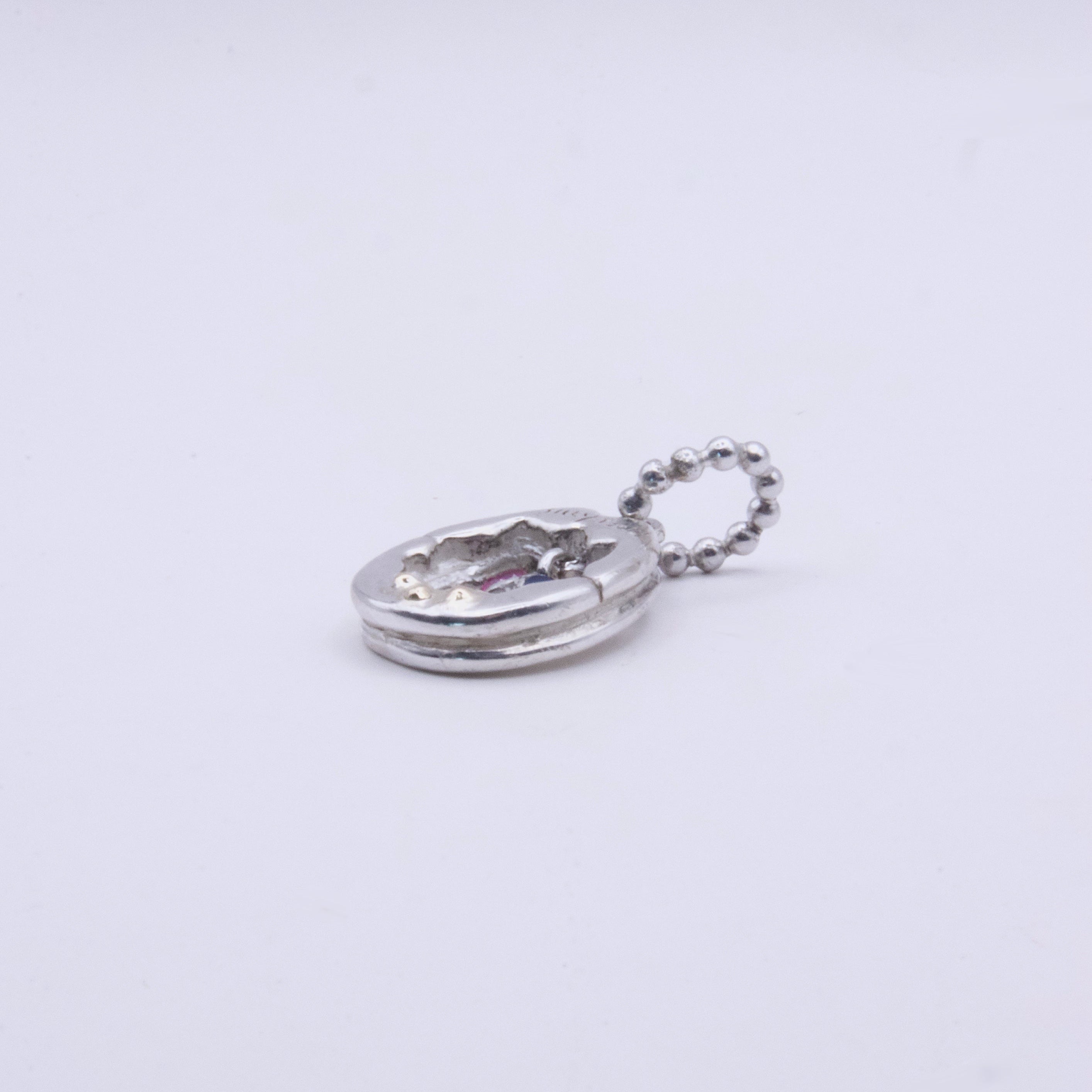 A small silver Y2K charm with a textured, hammered finish and a matching silver ball chain, shown on a plain white background.