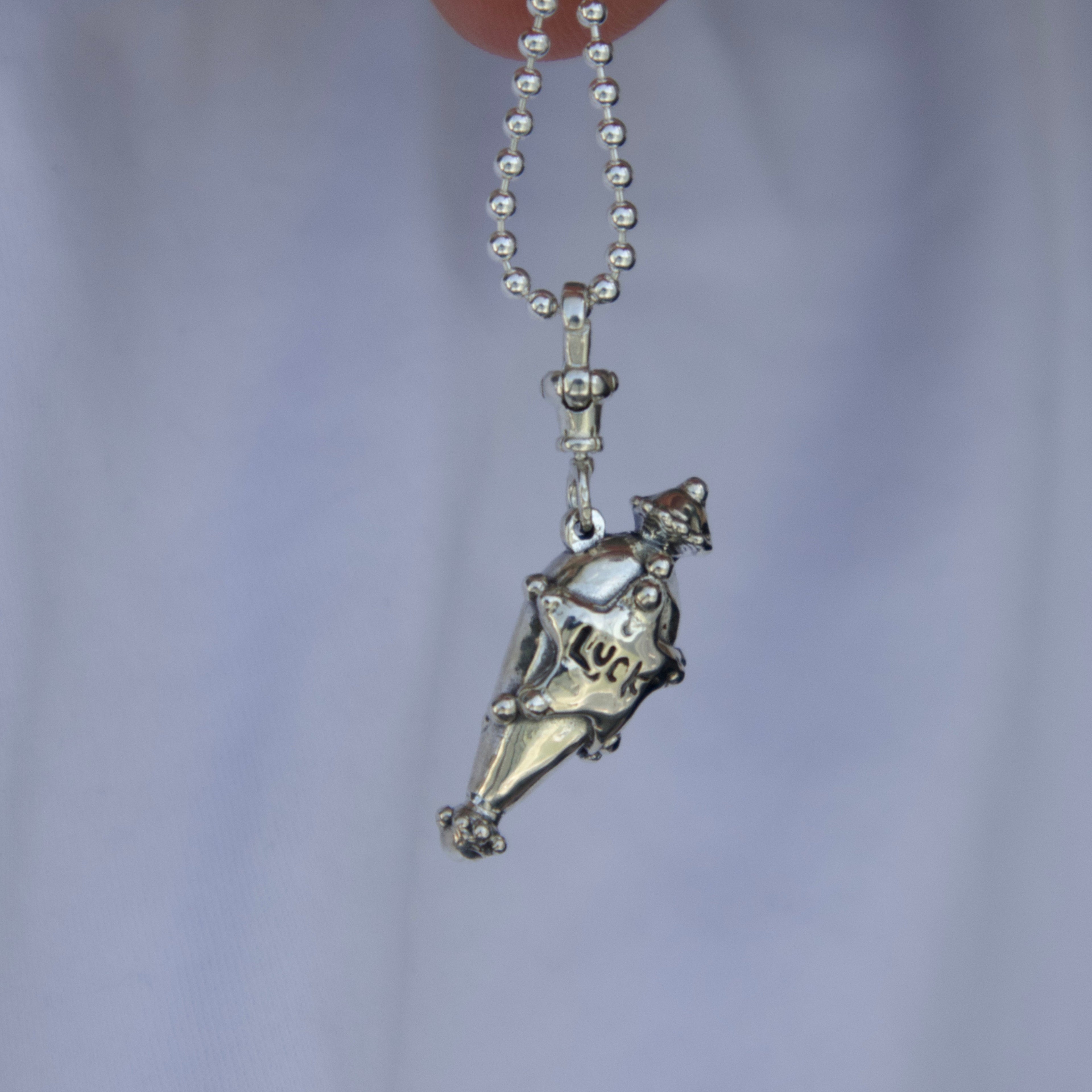 Sterling silver luck charm pendantagainst a light background